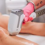 Close-up of laser hair removal on a client's leg in a professional clinic setting.